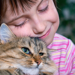 Portrait of a young beautiful child girl hug cuting funny cat with tenderness and love. Close up.
