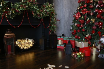 
beautiful New Year tree decorated with red and gold toys against a gray concrete wall in a luxury apartment