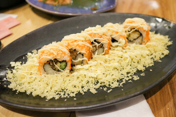 Fried flour on sushi  black plate