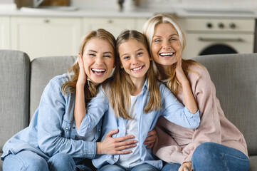 Three female generation. Happy caucasian grandmother, daughter and granddaughter are sitting at...