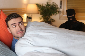 Man in bed surprised by an intruder