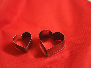 couple bread molds stainless Heart shaped on fabric red background, love Valentine Day for copy...