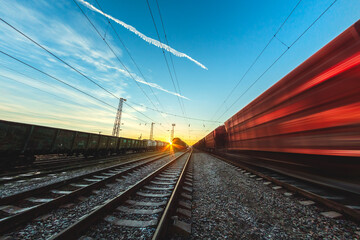 Fototapeta na wymiar High-speed train moves by rail, delivery of goods by freight train. Train carriages at the station