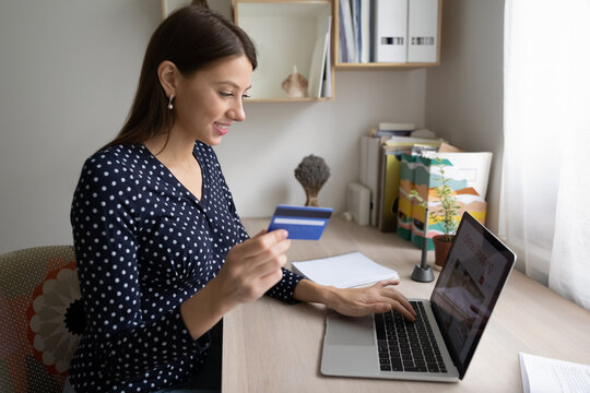 Easy Shopping. Happy Millennial Woman Customer Of Online Store Make Purchase From Home Office Using Laptop. Satisfied Female Client Of Web Shop Provide Cashless Payment For Ordered Goods Via Bank App