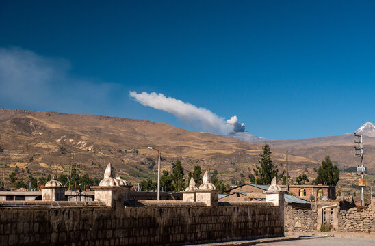 Yanque village with erupting volcano Mismi on the background, Peru