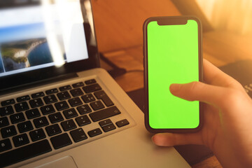 Homme tenant un téléphone portable cellulaire moderne (smartphone) avec un écran vert devant un...