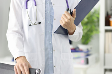 Silhouettes of doctor holding clipboard in medical office