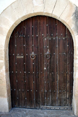 Fototapeta na wymiar Antique wooden arched door from the island of Ibiza, Spain.