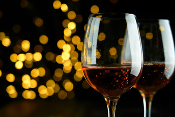 Two glasses of sparkling wine or champagne to celebrate Party or Anniversary with a yellow bokeh effect on dark background. 