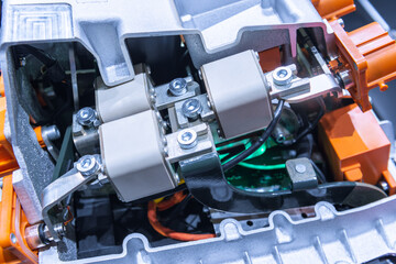 Chassis of the electric car with powertrain and power connections closeup. Blue toned. EV car drivetrain at maintenance.