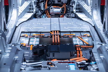 Chassis of the electric car with powertrain and power connections closeup. Blue toned. EV car...