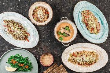 Several Asian dishes with noodles, rice and seaweed on different plates