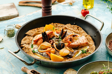 Seafood saute mix with cream sauce and herbs on the blue background