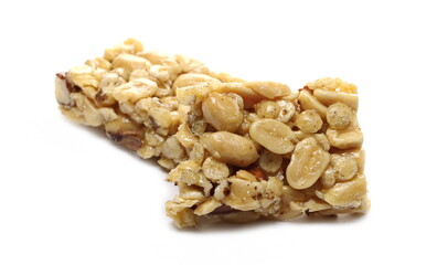 Honey granola nut bar broken in half with almonds, peanuts, walnuts and honey isolated on white background