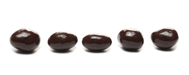 Chocolate coated raisins row isolated on white background
