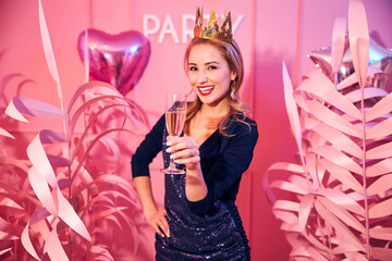 High-spirited lady with a glass of champagne looking ahead