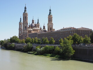 Brilliant basilica of our lady of the Pillar and Ebro river in european Saragossa city at Aragon district in Spain, clear blue sky in 2019 warm sunny summer day on September.