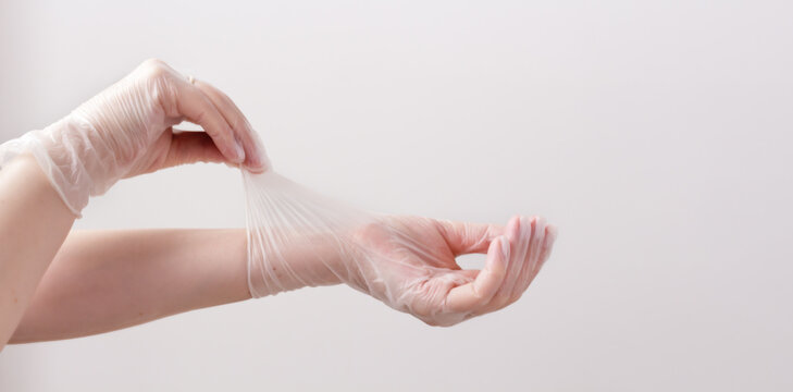Feminine hands in transparent vinyl gloves