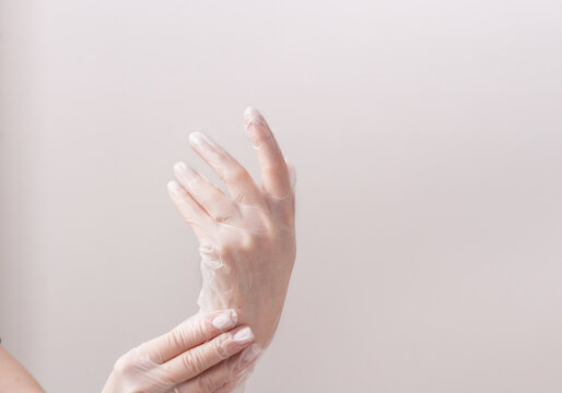 Feminine Hands In Transparent Vinyl Gloves.