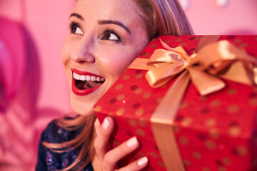 Pleased female with a gift box looking up