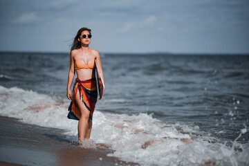 Asian beautiful young girl in bikini holding a surfboard at the beach.Summer Vacation. Water Sport.