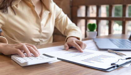 Financial businesswoman calculating corporate income tax data And analyzing charts of financial stocks that are in good condition with growth and progress,Finance and accounting industries.