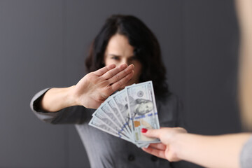 Woman makes negative gesture for money extended to her