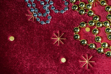 Background, texture. On a red background, Christmas tree decorations beads, gold and silver colors. Christmas.