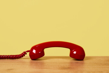 red telephone off the hook on a yellow background