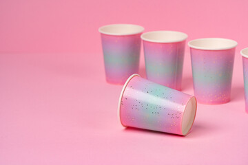Pink disposable paper cups on pink background