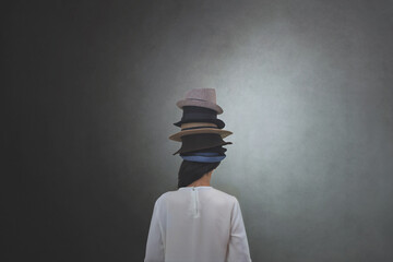 woman from behind wears countless hats on her head, concept of multiple personalities and identities - 408283367