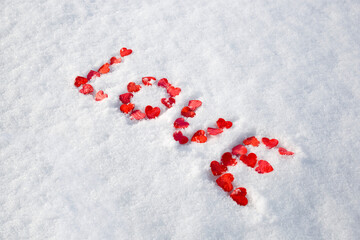 valentine's day concept: word love laid out with hearts on snow