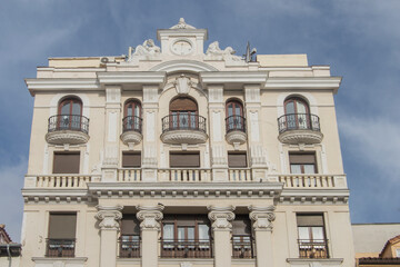 Fototapeta na wymiar historicist building in Madrid with balconies, windows and balustrades and on top a sundial