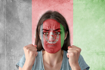 Flag of Afghanistan painted on a face of a anxious young woman
