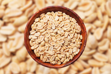 Peanuts in wooden bowl isolated. No shell nuts texture. Peeled peanuts background.