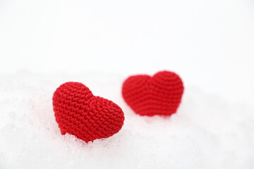 Valentine hearts in the snow. Two red knitted hearts in winter, symbol of romantic love, background for holiday
