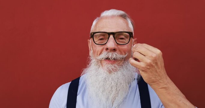 Crazy hipster man touching his moustache in front of the camera - Joyful elderly lifestyle concept