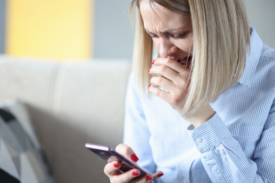 Woman cries and looks at smartphone screen - Powered by Adobe