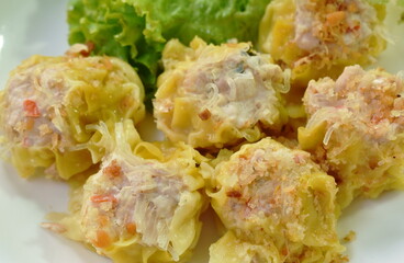 Chinese dumpling stuffed chop pork and glass noodles topping fried garlic with lettuce on plate dipping sweet soybean sauce