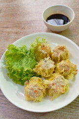 Chinese dumpling stuffed chop pork and glass noodles topping fried garlic with lettuce on plate dipping sweet soybean sauce