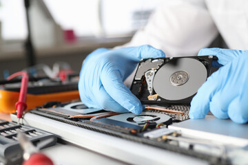 Naklejka premium Gloved master holds a hard drive closeup