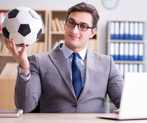 Businessman with football ball in office