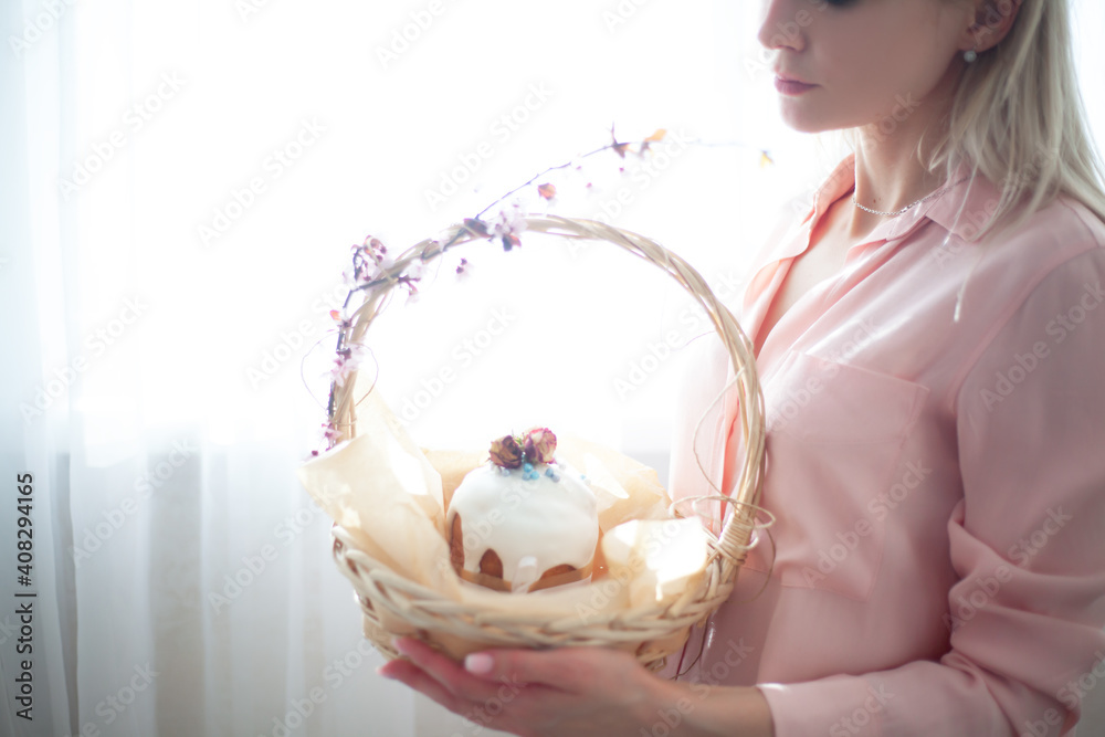 Wall mural Woman hands holding traditional russian easter cake on table. The decorarion of kulich are the flower are eating on spring holiday