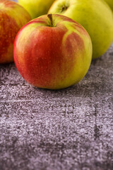 Green and red apples on blackboard or chalkboard background. Close-up on a gray background.Ideal food for diet.