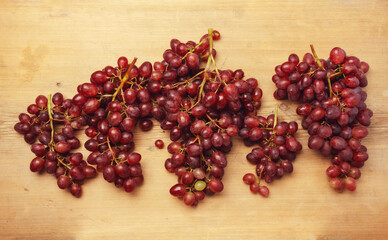 Fresh red grapes on a wooden table.