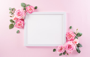 Happy women's day concept, pink roses with white picture frame on pastel background