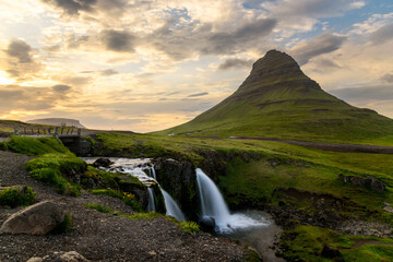 View of Kirkjufell mountain and waterfalls lit by midnight sun in smmer. Northern Iceland.