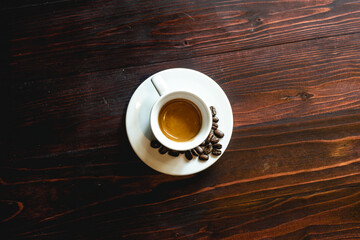Coffee cup and coffee beans on white table.