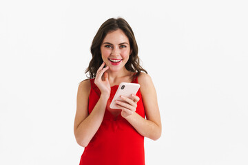 Joyful beautiful girl wearing red dress using mobile phone