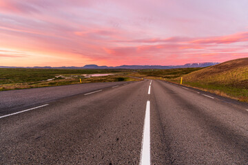Fototapeta premium Majestic summer sunset over a winding mountain road leading down to a valley. Myvatn, Iceland.